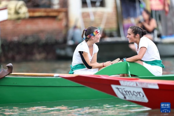 9月7日,在意大利威尼斯,“划行威尼斯”成员埃莱娜·阿尔曼西(左)与队友获得传统赛船节成年女子组第三名后庆祝。新华社记者 李京 摄