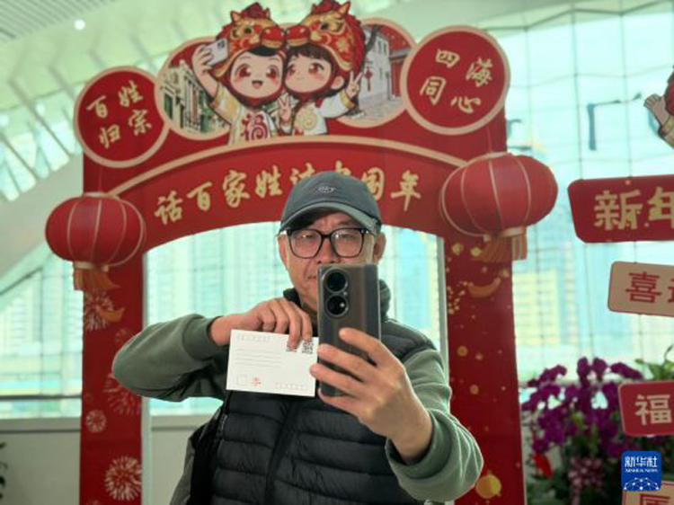 小小电商年货火热是两岸经贸合作共赢的缩影 小小电商年货火热是两岸经贸合作共赢的缩影_fororder_2月10日,在厦门站“话百家姓 过中国年”主题文化活动现场,台胞李高雄拿着专属姓氏明信片自拍留念。新华社记者 付敏 摄