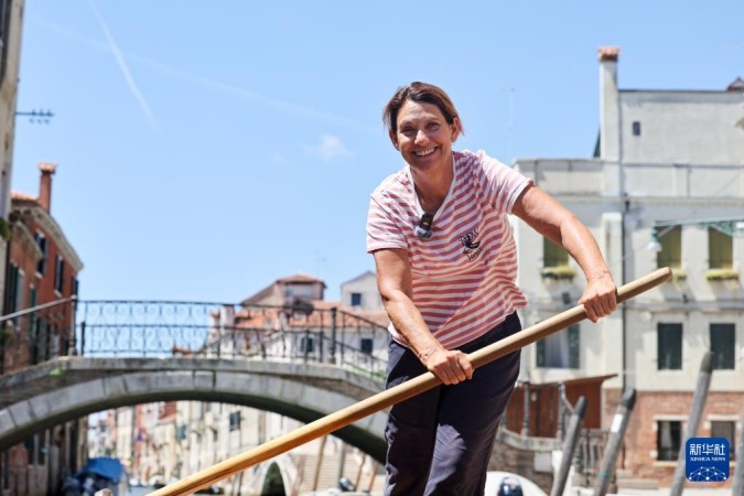 7月17日,在意大利威尼斯,“划行威尼斯”创始人简·卡波拉尔在运河上驾驶虾尾平底船。新华社记者 李京 摄