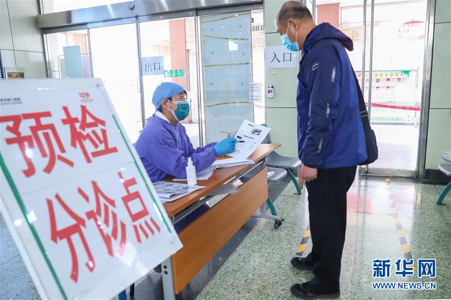 3月23日，工作人員（左）在北京市普仁醫(yī)院門診向市民講解如何預約掛號。普仁醫(yī)院之前是北京市東城區(qū)新冠肺炎醫(yī)療救治定點醫(yī)院。  新華社記者 張玉薇 攝