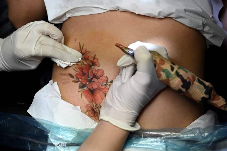 Vietnamese Tattoo Artist: Transforming Scars into Art_fororder_VCG111324926675