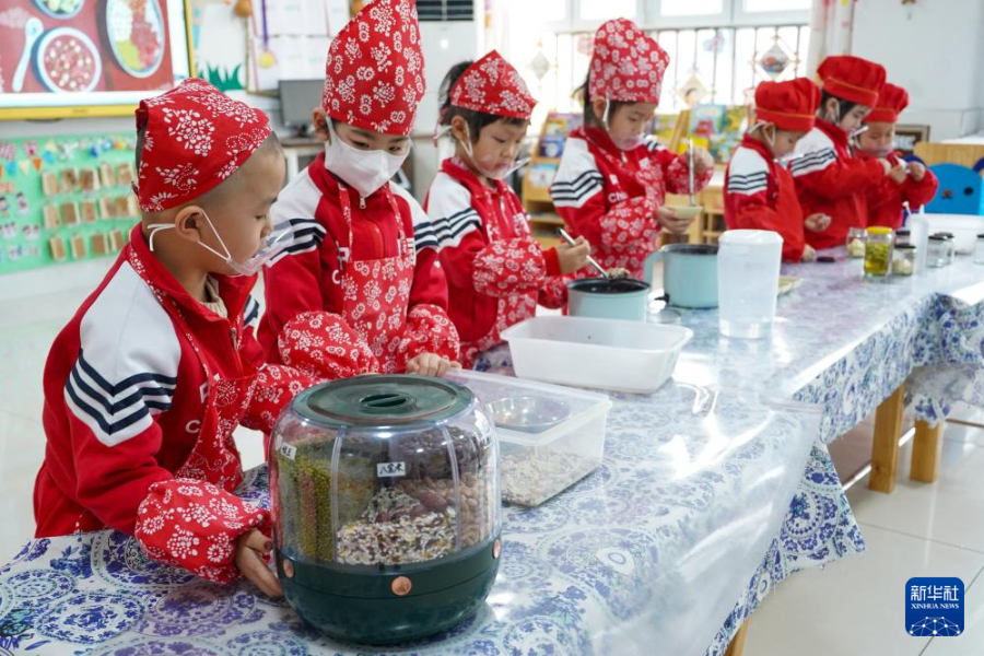 1月17日，河北省唐山市豐南區(qū)群立幼兒園的小朋友在體驗制作臘八粥。新華社發(fā) （李秀清攝）