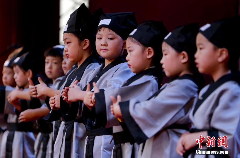 7月1日，有著“人生第一大禮”之稱的華夏禮儀“開(kāi)筆禮”在北京大觀園舉行展演活動(dòng)，孩子們身著漢服在老師的指引下祭拜孔子，原汁原味的展示了傳統(tǒng)古代學(xué)生入學(xué)的第一課。當(dāng)日，北京大觀園情系紅樓傳統(tǒng)文化基地舉行了盛大的啟動(dòng)儀式。圖為身著漢服的孩子們?cè)谡故鹃_(kāi)筆禮。中新社發(fā) 陸欣 攝