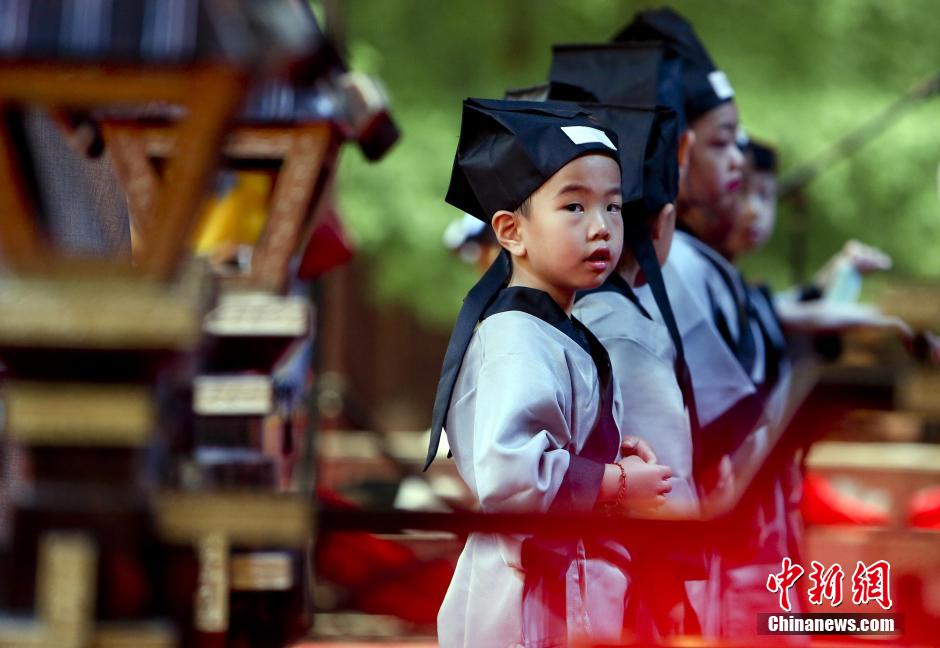 7月1日，有著“人生第一大禮”之稱的華夏禮儀“開(kāi)筆禮”在北京大觀園舉行展演活動(dòng)，孩子們身著漢服在老師的指引下祭拜孔子，原汁原味的展示了傳統(tǒng)古代學(xué)生入學(xué)的第一課。當(dāng)日，北京大觀園情系紅樓傳統(tǒng)文化基地舉行了盛大的啟動(dòng)儀式。圖為身著漢服的孩子們?cè)谡故鹃_(kāi)筆禮。中新社發(fā) 陸欣 攝