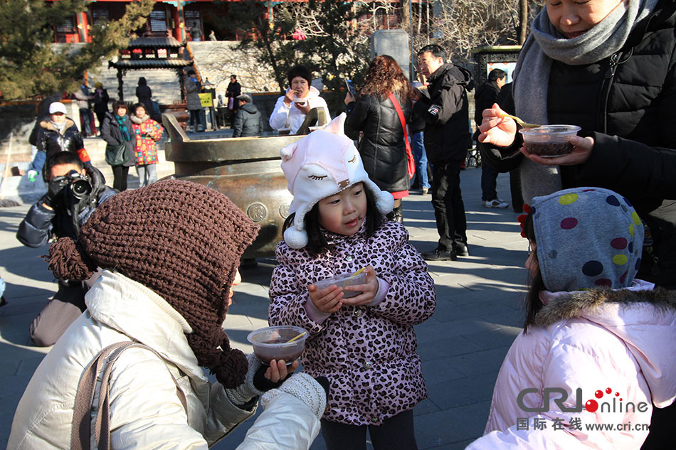 雖然天氣寒冷，不少家長選擇帶著孩子來到潭柘寺，參加這一舍粥活動(dòng)。攝影：沈湜