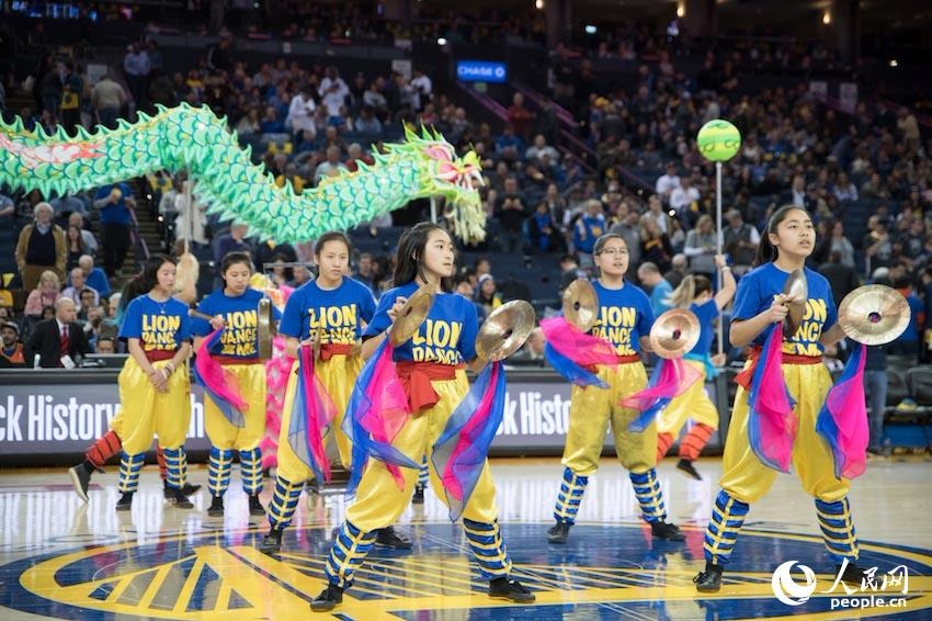 当地时间2月24日晚,2017-18赛季NBA常规赛期间,金州勇士队对阵俄克拉荷马雷霆队的比赛中场休息时,当地演员献上舞龙舞狮表演。人民网 张洁娴 摄