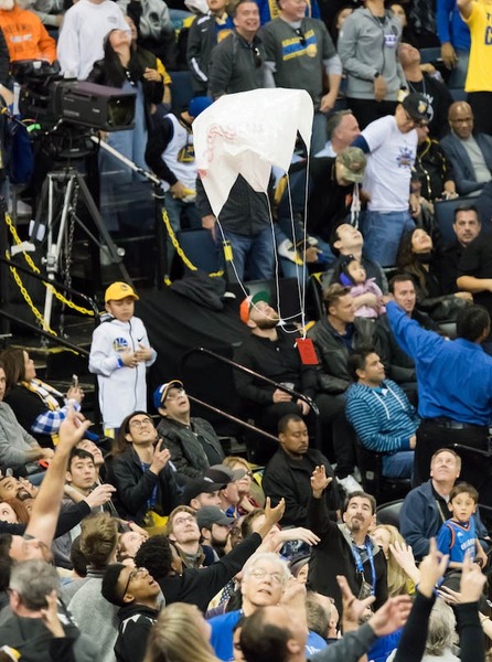 当地时间2月24日晚,2017-18赛季NBA常规赛期间,金州勇士队对阵俄克拉荷马雷霆队的比赛间隙,赛场向观众发放红包降落伞。人民网 张洁娴 摄