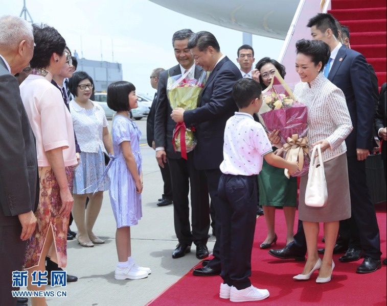 習(xí)近平和夫人彭麗媛在舷梯旁接受兩名香港少年敬獻(xiàn)鮮花。新華社記者 蘭紅光 攝