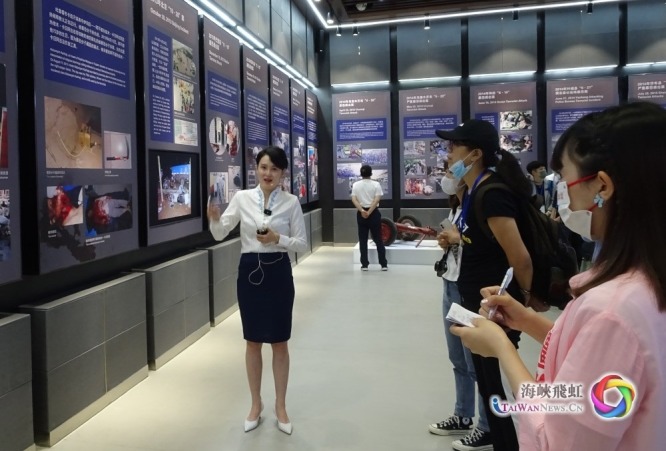 海峡两岸联合采访团的成员认真聆听讲解员的讲解