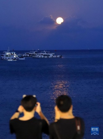 9月10日晚，游客在浙江舟山烏石塘景區(qū)觀賞“海上生明月”景觀。新華社發(fā)（邢守秒 攝）